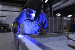 焊接工简约工人头戴保护罩工作在工厂背景图片